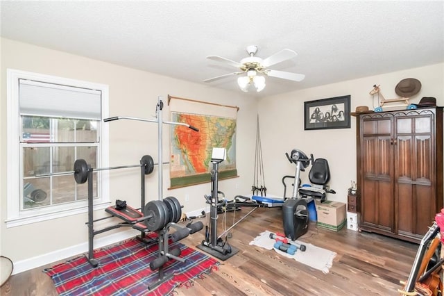 exercise area featuring ceiling fan, wood finished floors, and baseboards