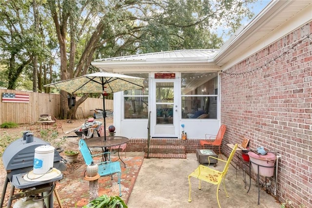 view of patio / terrace with entry steps, a sunroom, fence, and area for grilling