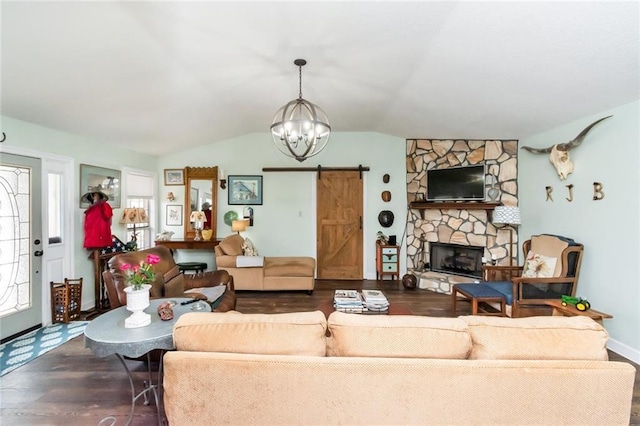 living room with a chandelier, a barn door, a fireplace, wood finished floors, and vaulted ceiling