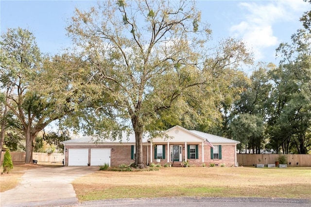 single story home with brick siding, an attached garage, a front yard, fence, and driveway