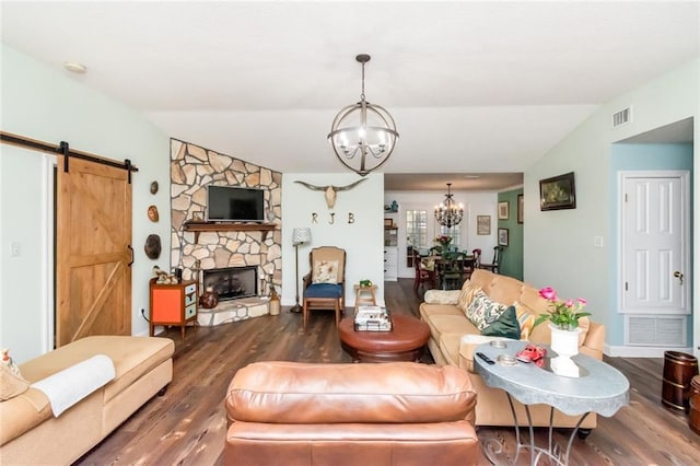 living area featuring a chandelier, visible vents, vaulted ceiling, and a barn door