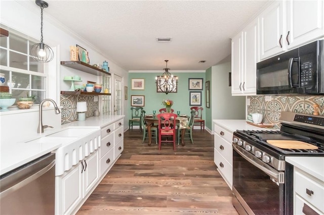 kitchen with white cabinets, stainless steel appliances, a sink, and wood finished floors