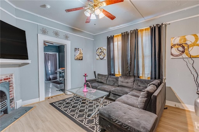 living room with hardwood / wood-style flooring, ceiling fan, and ornamental molding