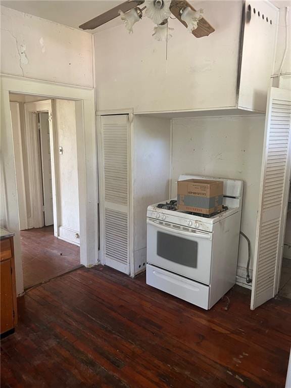 kitchen with dark wood-type flooring, ceiling fan, and gas range gas stove