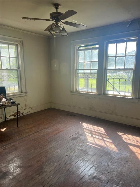 empty room with ceiling fan, crown molding, and dark hardwood / wood-style floors