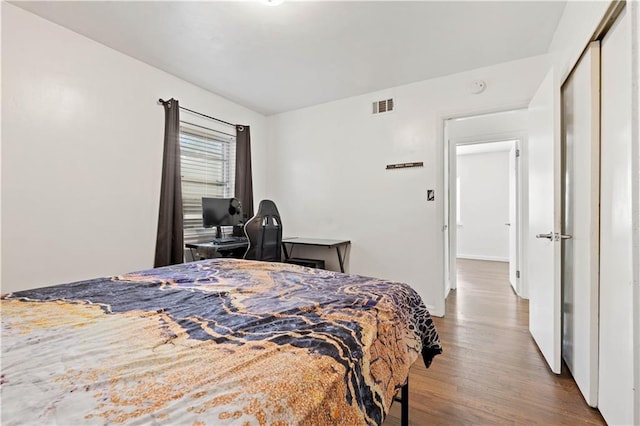 bedroom with a closet and hardwood / wood-style floors