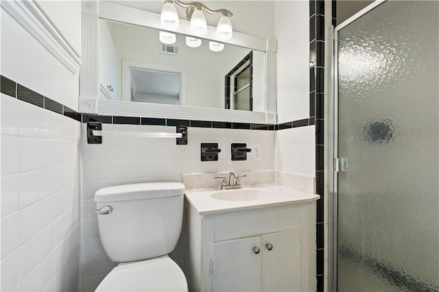 bathroom with vanity, toilet, walk in shower, and tile walls