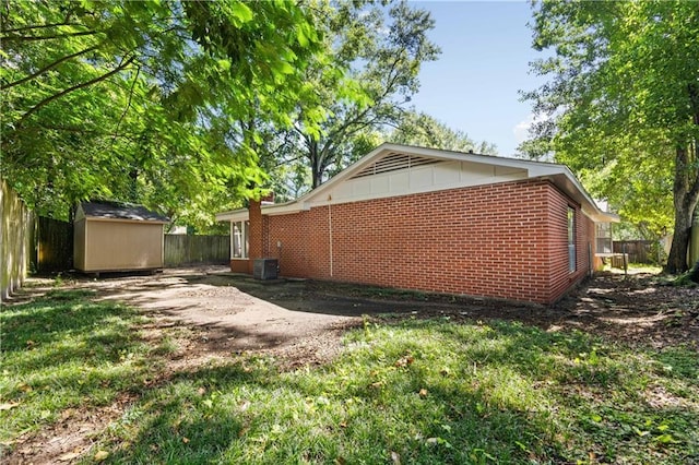 view of property exterior with central AC unit and a shed