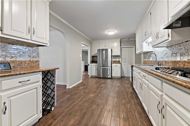 kitchen with appliances with stainless steel finishes, dark hardwood / wood-style flooring, crown molding, sink, and white cabinets