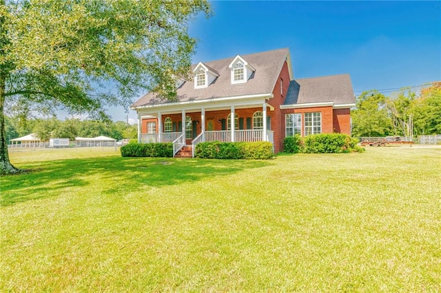 cape cod-style house featuring a porch and a front yard