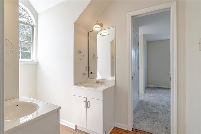 bathroom with vanity, lofted ceiling, and hardwood / wood-style floors