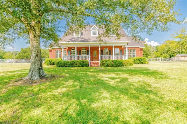 new england style home with covered porch and a front yard