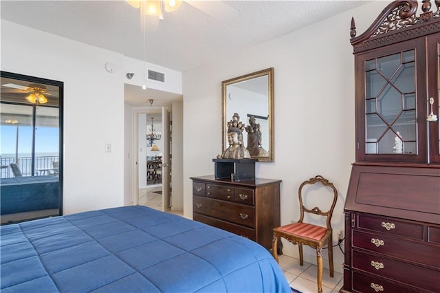 tiled bedroom with access to outside, a textured ceiling, and ceiling fan