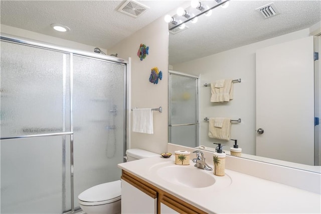 bathroom featuring an enclosed shower, vanity, a textured ceiling, and toilet