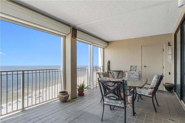 sunroom / solarium featuring a water view