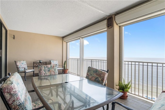 sunroom / solarium featuring a water view