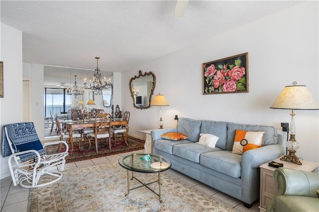 living room featuring a notable chandelier, a textured ceiling, and light tile flooring