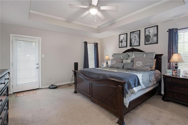 bedroom featuring crown molding, light colored carpet, and a tray ceiling