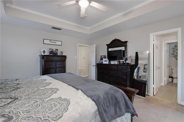 carpeted bedroom with ornamental molding, ceiling fan, and a tray ceiling