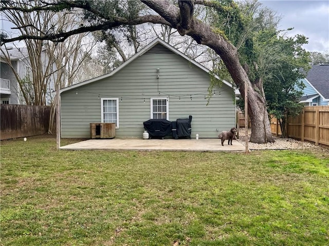 back of property with a yard and a patio area