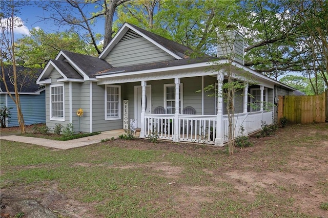 view of front of home with a porch and a front yard