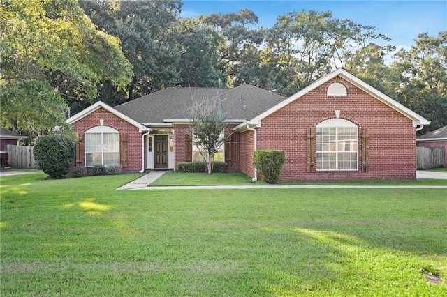 single story home featuring a front yard, brick siding, fence, and roof with shingles