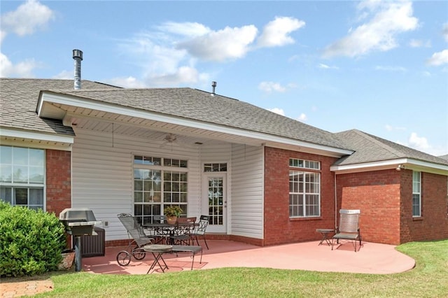 9633 White Castle Rd, Mobile, AL 36695 - back of property featuring brick siding, a patio area, a shingled roof, and a lawn