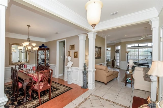 9633 White Castle Rd, Mobile, AL 36695 - dining area featuring ornate columns, a decorative wall, wainscoting, a chandelier, and a ceiling fan