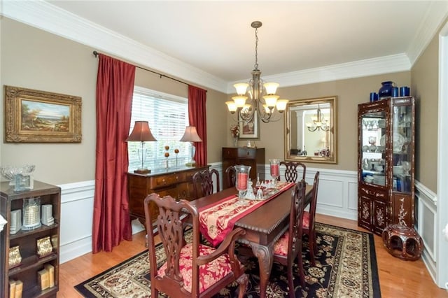 9633 White Castle Rd, Mobile, AL 36695 - dining space featuring a chandelier, crown molding, a wainscoted wall, light wood-style flooring, and a decorative wall