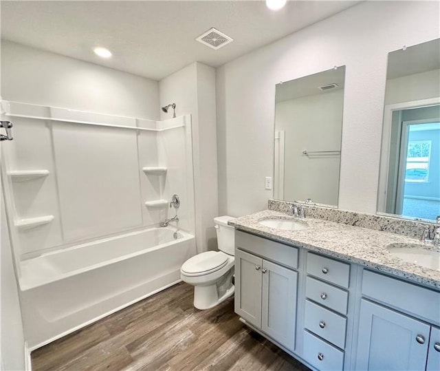 full bathroom featuring vanity, hardwood / wood-style flooring, toilet, and shower / washtub combination