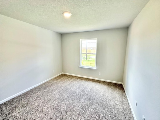 carpeted empty room featuring a textured ceiling