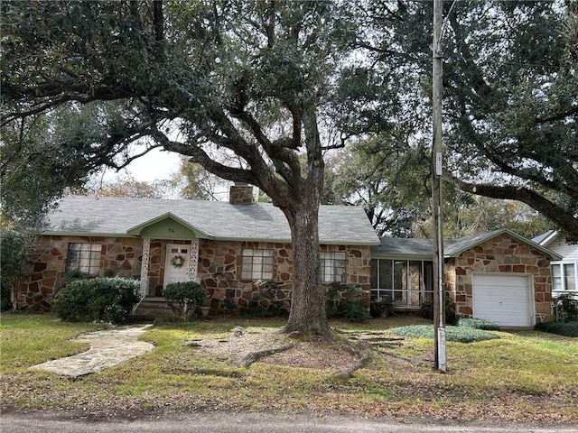 single story home featuring a garage, a sunroom, and a front yard