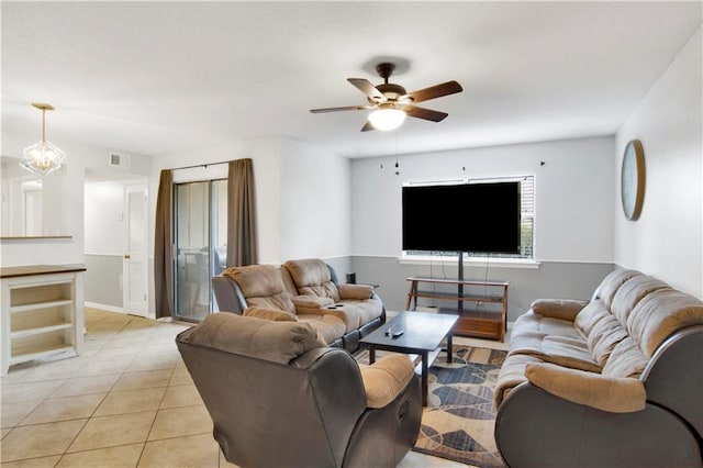 living room with ceiling fan with notable chandelier and light tile patterned floors