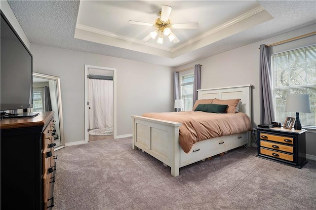 carpeted bedroom with a raised ceiling, crown molding, and baseboards