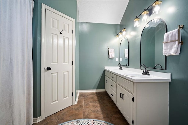 full bathroom featuring double vanity, baseboards, tile patterned floors, and a sink