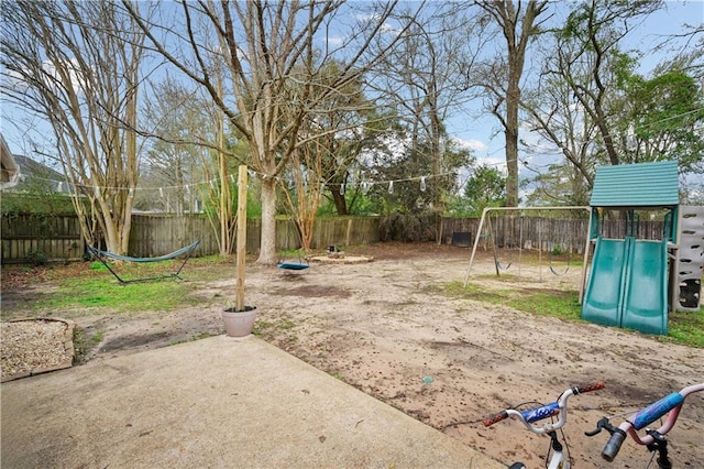 view of yard featuring a patio, a playground, and a fenced backyard