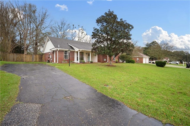 single story home with driveway, brick siding, a front yard, and fence