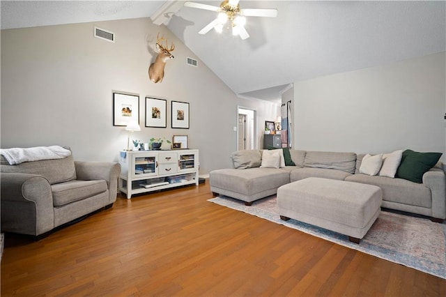 living room with beam ceiling, visible vents, ceiling fan, and wood finished floors