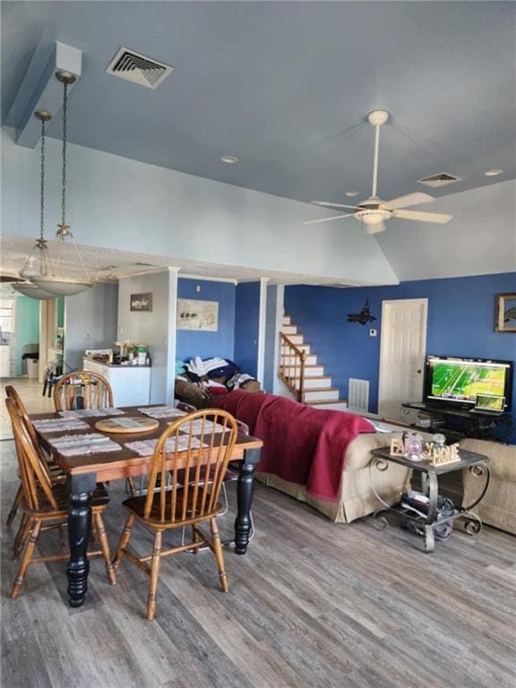 829 Desoto Dr, Dauphin Island, AL 36528 - dining area featuring wood finished floors, a ceiling fan, vaulted ceiling, and stairs