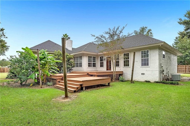 rear view of property featuring a deck and a lawn