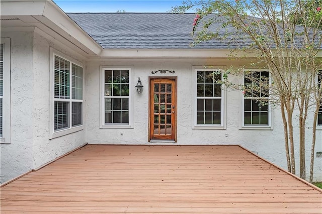 view of exterior entry featuring a wooden deck