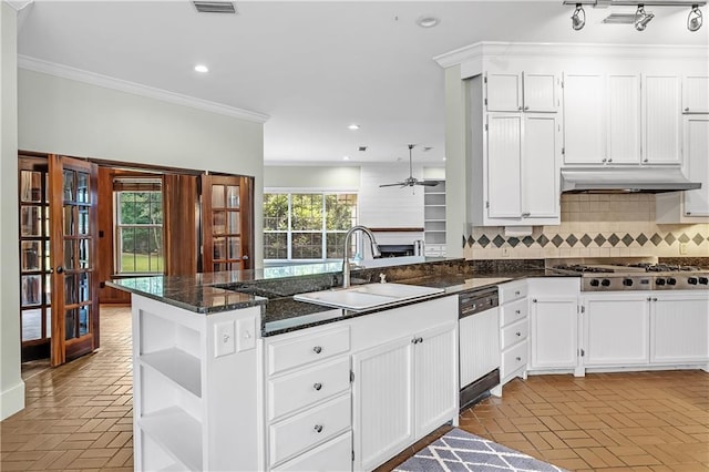 kitchen with sink, dark stone countertops, ornamental molding, and decorative backsplash