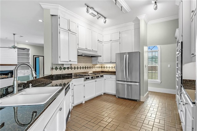 kitchen featuring appliances with stainless steel finishes, white cabinetry, tasteful backsplash, track lighting, and ceiling fan