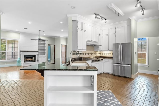 kitchen featuring sink, light wood-type flooring, tasteful backsplash, stainless steel appliances, and kitchen peninsula