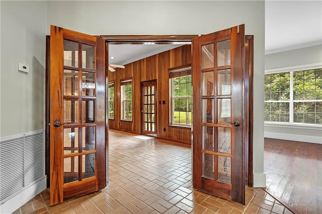 interior space featuring light wood-type flooring, ornamental molding, and french doors