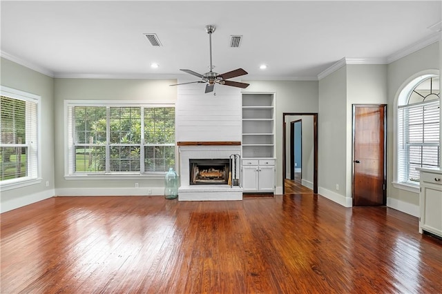 unfurnished living room featuring a wealth of natural light, a fireplace, hardwood / wood-style floors, and ceiling fan