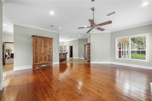 unfurnished living room with ceiling fan, crown molding, and wood-type flooring