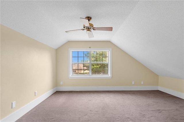 bonus room featuring a textured ceiling, ceiling fan, carpet, and vaulted ceiling