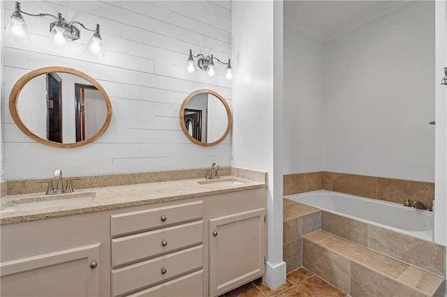 bathroom featuring tiled tub, ornamental molding, vanity, and tile patterned floors