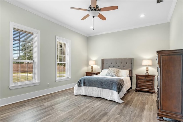 bedroom featuring ceiling fan, light hardwood / wood-style floors, and ornamental molding